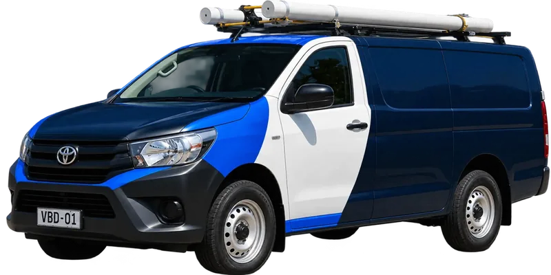 A licensed Blacktown plumbing van loaded with pipe on the roof rack